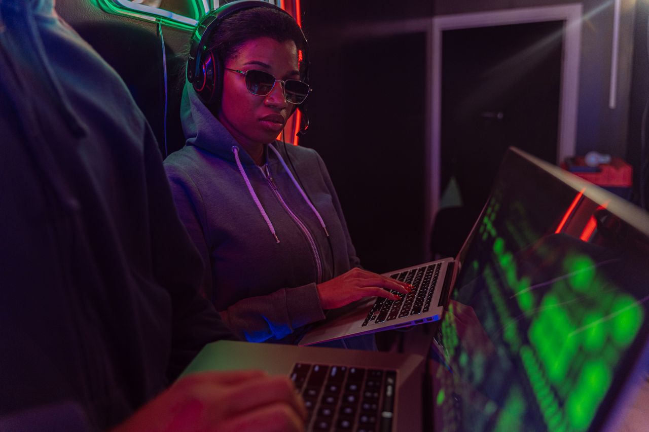 A tech-savvy adult using a laptop at night with neon lighting, creating a cyberpunk ambiance.